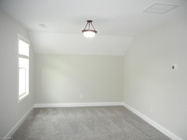 715 Cannonade Dr, Whitsett, NC 27377 - additional living space with lofted ceiling, carpet flooring, and plenty of natural light