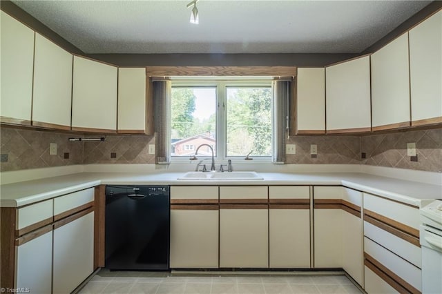 kitchen featuring dishwasher, a sink, light countertops, backsplash, and a textured ceiling