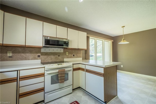 kitchen featuring stainless steel microwave, white electric stove, a peninsula, backsplash, and light countertops