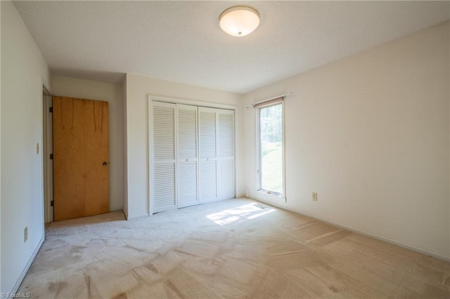 unfurnished bedroom featuring carpet floors, a closet, and baseboards