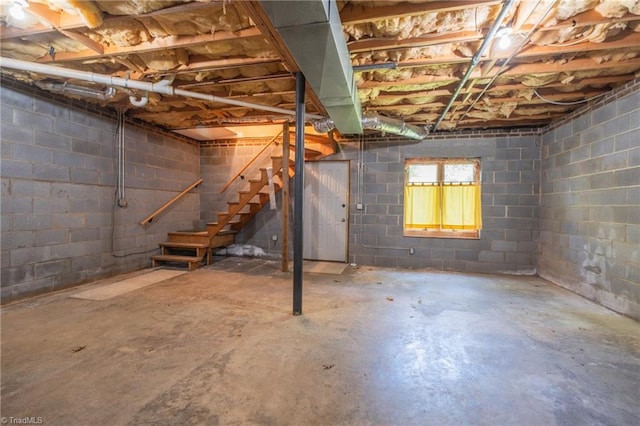 basement featuring stairs and concrete block wall
