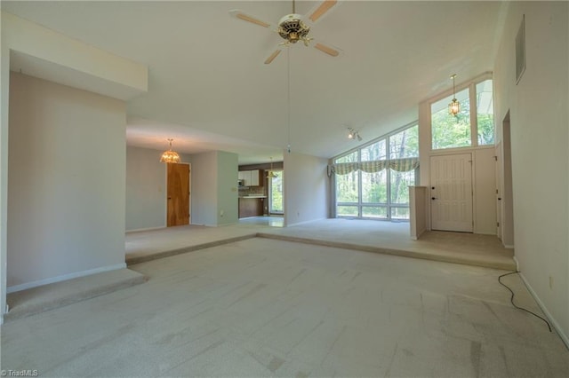 unfurnished living room with carpet floors, baseboards, ceiling fan, and high vaulted ceiling