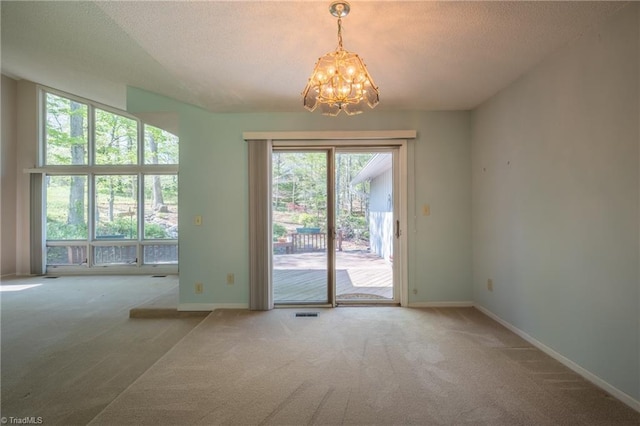 entryway featuring carpet, a chandelier, baseboards, and a textured ceiling
