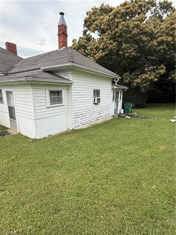 535 Worth St, Mount Airy, NC 27030 - rear view of house featuring a lawn, a chimney, and a shingled roof