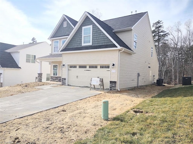 view of front of property featuring cooling unit, a garage, and a front yard