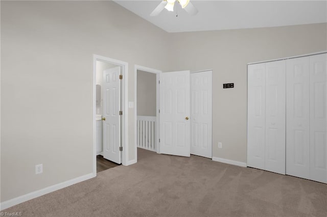 unfurnished bedroom featuring ceiling fan, carpet, high vaulted ceiling, and multiple closets