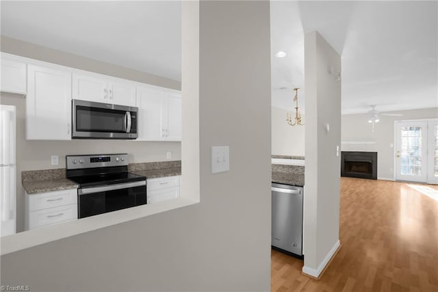 kitchen featuring light hardwood / wood-style floors, white cabinetry, appliances with stainless steel finishes, and ceiling fan