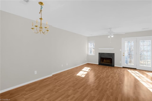 unfurnished living room with wood-type flooring and ceiling fan with notable chandelier