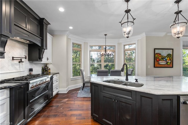 kitchen with decorative backsplash, dark wood-type flooring, sink, pendant lighting, and a chandelier