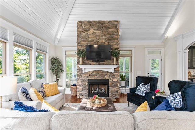 living room featuring wood-type flooring, lofted ceiling, and a fireplace