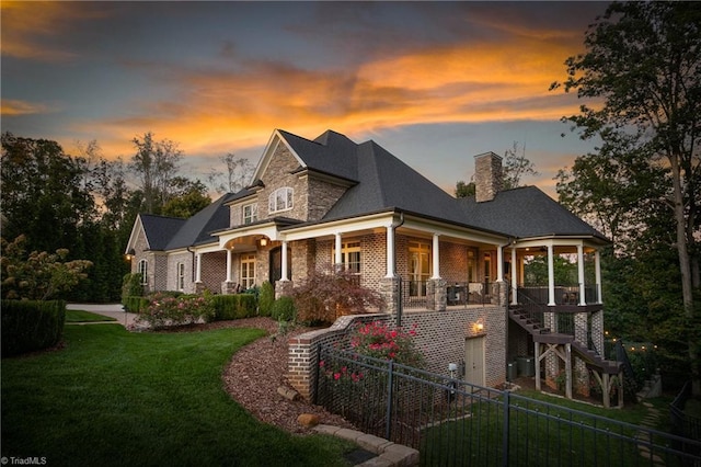 view of front of property with a porch and a yard