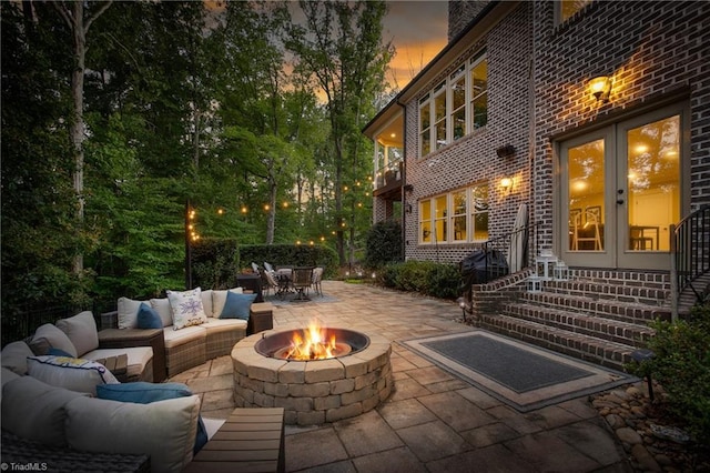 patio terrace at dusk with an outdoor living space with a fire pit