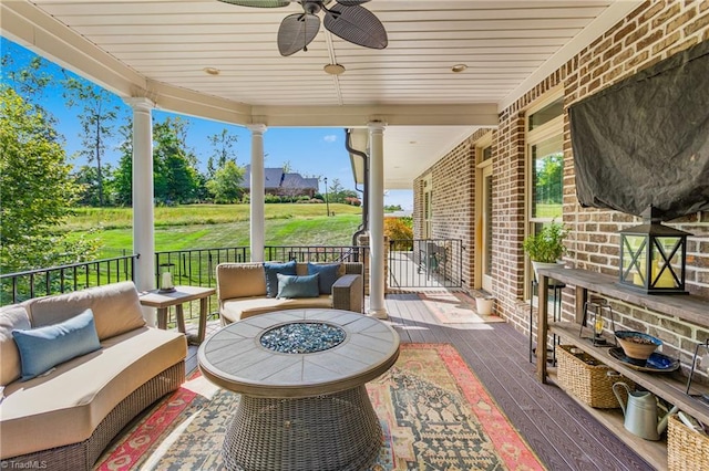 view of patio / terrace with ceiling fan and an outdoor living space with a fire pit