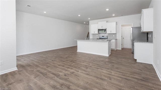 1372 Amberview Ln, Kernersville, NC 27284 - kitchen with dark wood finished floors, tasteful backsplash, white cabinets, stainless steel appliances, and open floor plan