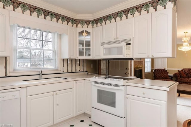 kitchen with white cabinetry, sink, ornamental molding, kitchen peninsula, and white appliances