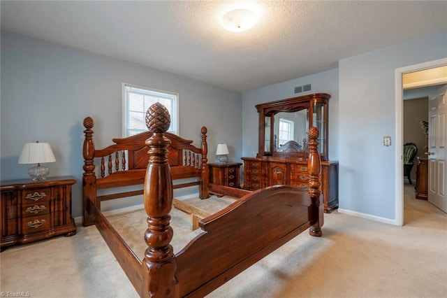 bedroom with light colored carpet and a textured ceiling