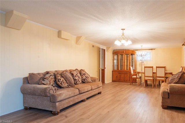 living room with hardwood / wood-style flooring, ornamental molding, and a chandelier