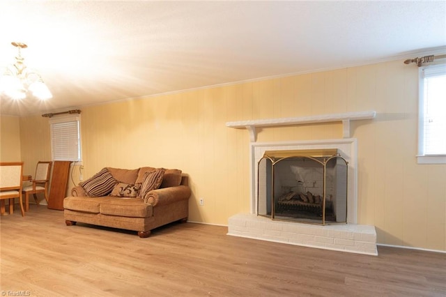 living room with wood-type flooring, a brick fireplace, and ornamental molding