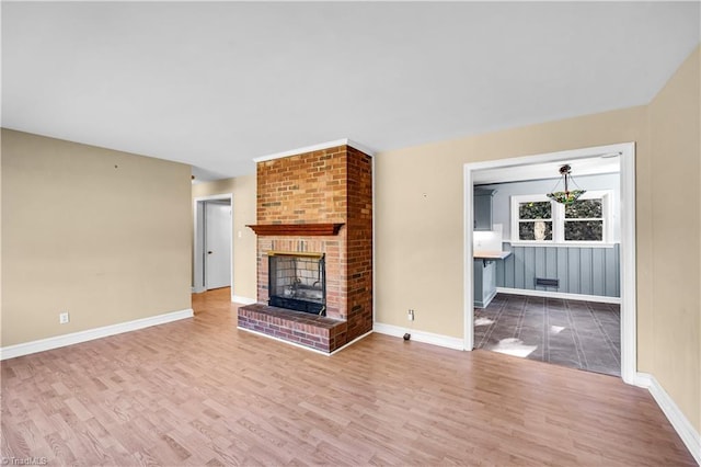 unfurnished living room with hardwood / wood-style flooring and a brick fireplace