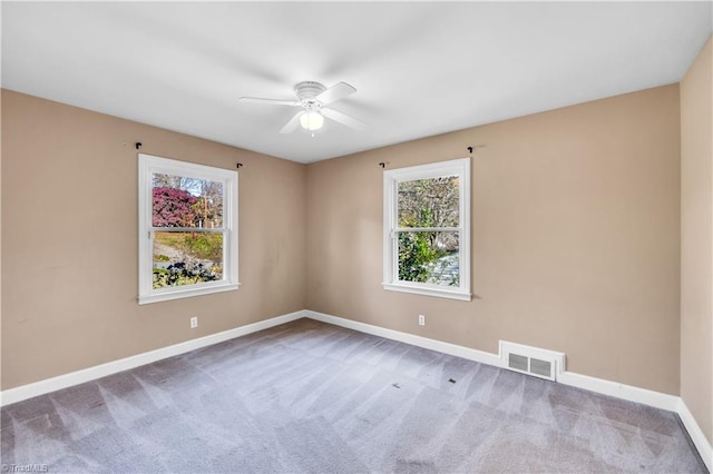 carpeted spare room featuring ceiling fan