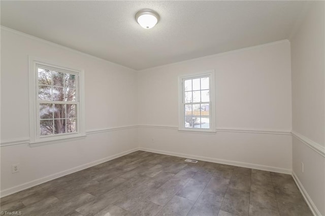 unfurnished room featuring ornamental molding and a textured ceiling