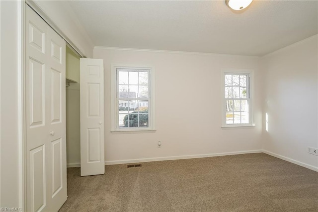 unfurnished bedroom with multiple windows, ornamental molding, and carpet