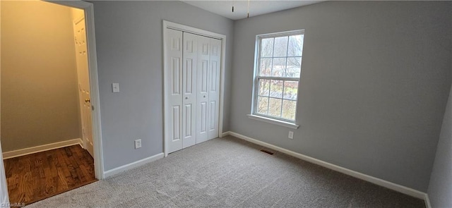 unfurnished bedroom with a closet, carpet flooring, and multiple windows