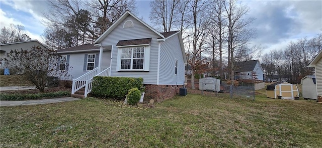 view of front of house featuring central AC, a storage unit, and a front yard