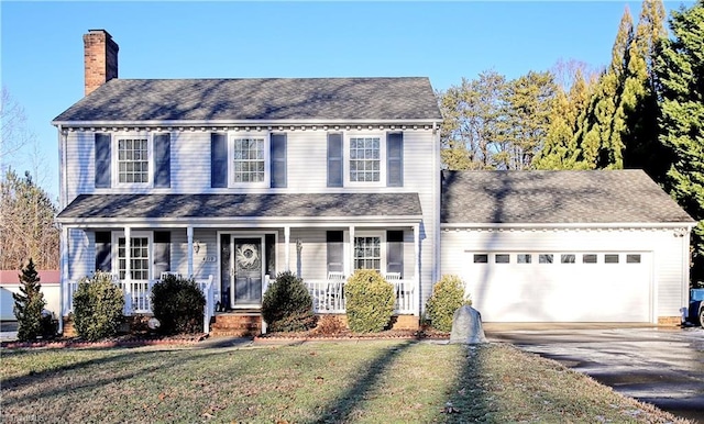 colonial-style house featuring a garage and a front yard