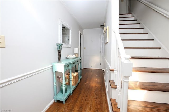 staircase with hardwood / wood-style floors and ornamental molding