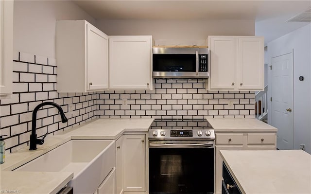 5430 Strasburg Dr, Greensboro, NC 27407 - kitchen with appliances with stainless steel finishes, a sink, white cabinets, and light countertops