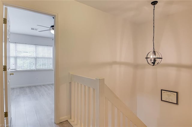 5430 Strasburg Dr, Greensboro, NC 27407 - hall with an upstairs landing, a chandelier, baseboards, and light wood-style flooring