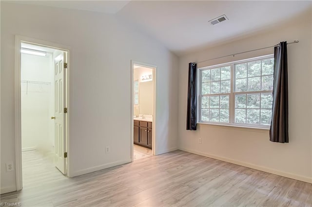 5430 Strasburg Dr, Greensboro, NC 27407 - unfurnished bedroom featuring light wood-type flooring, lofted ceiling, and baseboards