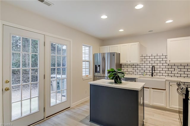 5430 Strasburg Dr, Greensboro, NC 27407 - kitchen featuring a sink, stainless steel fridge with ice dispenser, tasteful backsplash, light countertops, and white cabinetry