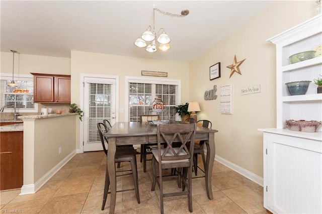 dining room with light tile patterned flooring, sink, and an inviting chandelier