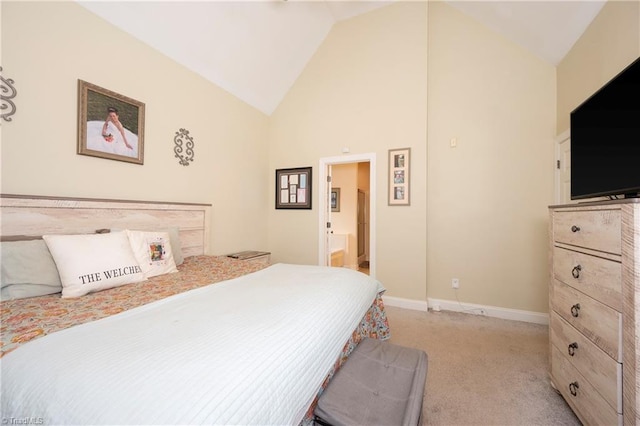 bedroom with high vaulted ceiling, light colored carpet, and connected bathroom