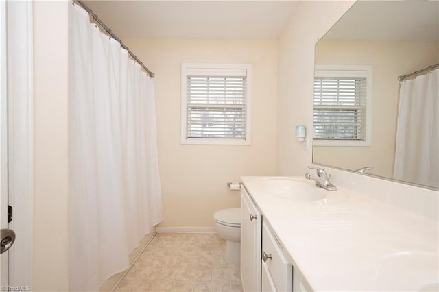 bathroom featuring vanity, a healthy amount of sunlight, and toilet