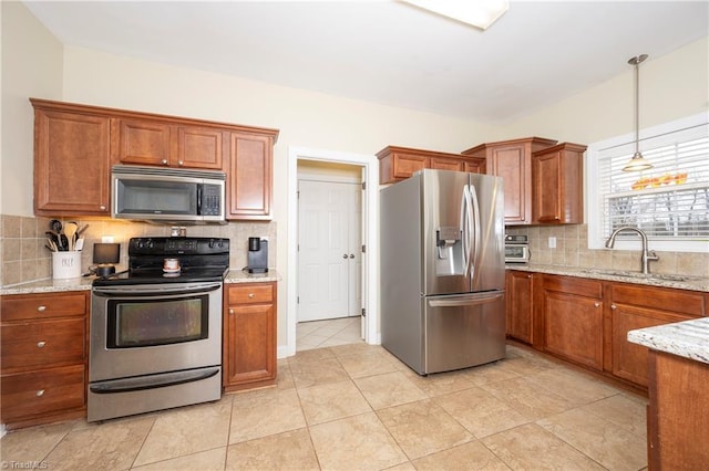 kitchen featuring backsplash, light stone counters, stainless steel appliances, sink, and light tile patterned floors