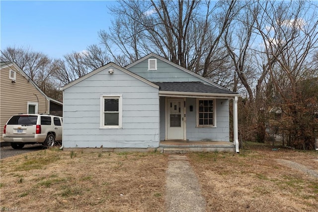 bungalow with a porch and a front lawn