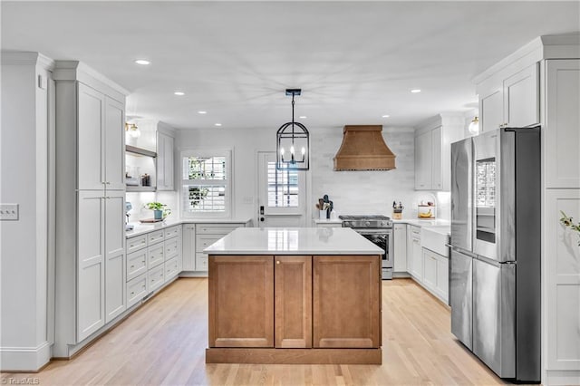 3480 York Rd, Winston-Salem, NC 27104 - kitchen with stainless steel appliances, custom range hood, light wood-style floors, a center island, and light countertops