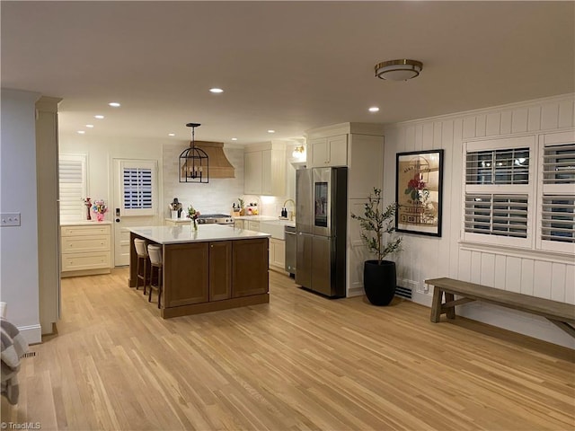 3480 York Rd, Winston-Salem, NC 27104 - kitchen featuring appliances with stainless steel finishes, light countertops, light wood finished floors, a sink, and hanging light fixtures