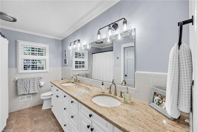 3480 York Rd, Winston-Salem, NC 27104 - bathroom with tile walls, tile patterned floors, double vanity, toilet, and a wainscoted wall