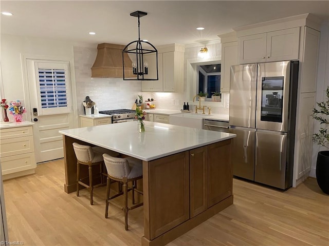 3480 York Rd, Winston-Salem, NC 27104 - kitchen featuring appliances with stainless steel finishes, custom exhaust hood, light wood-style floors, light countertops, and recessed lighting