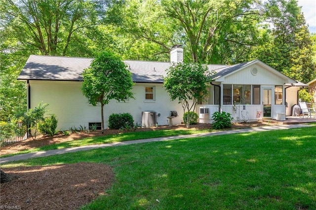 3480 York Rd, Winston-Salem, NC 27104 - back of house with a sunroom, a lawn, a chimney, brick siding, and central AC unit