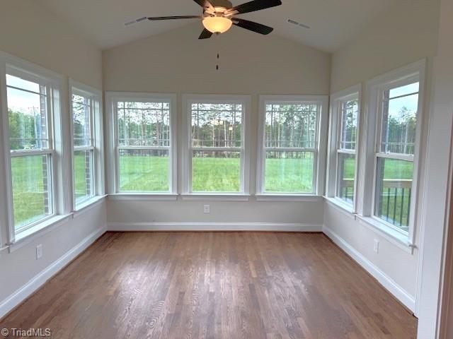 7607 Valhalla Way Lot 20, Greensboro, NC 27409 - unfurnished sunroom featuring wood finished floors, visible vents, vaulted ceiling, and baseboards