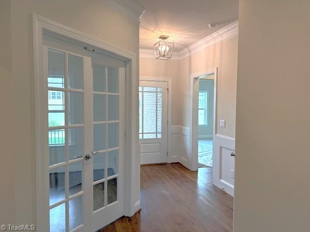 7607 Valhalla Way Lot 20, Greensboro, NC 27409 - doorway to outside featuring wood finished floors, an inviting chandelier, wainscoting, ornamental molding, and french doors