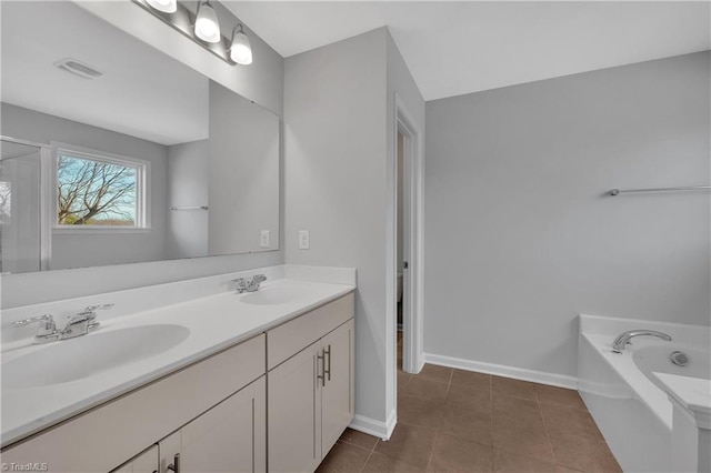 bathroom featuring tile patterned floors, vanity, and a bathing tub