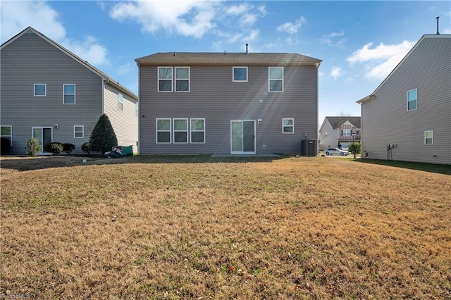 rear view of property with a yard and central air condition unit