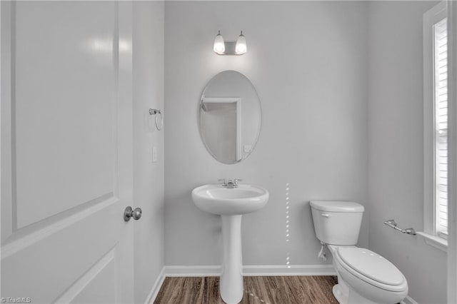 bathroom with toilet and hardwood / wood-style floors