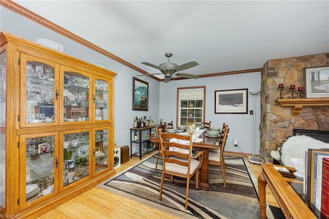 1973 Old Mountain Rd, Thomasville, NC 27360 - dining room featuring ceiling fan, wood finished floors, crown molding, and a stone fireplace
